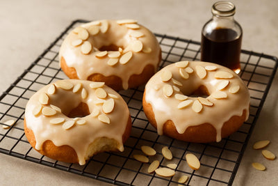 Doughnuts finished with almond glaze on a cooling rack