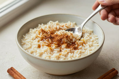 Creamy brown sugar cinnamon rice pudding in a small ceramic bowl with a spoon, garnished as in the recipe