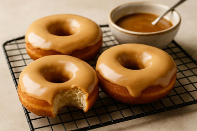 Doughnuts finished with caramelized white chocolate glaze on a cooling rack
