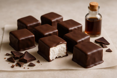 Homemade chocolate dipped marshmallow squares on parchment