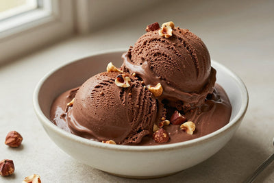 Two generous scoops of chocolate hazelnut ice cream in a shallow ceramic bowl, softly melting at the edges