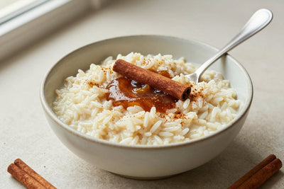 Creamy cinnamon rice pudding in a small ceramic bowl with a spoon, garnished as in the recipe