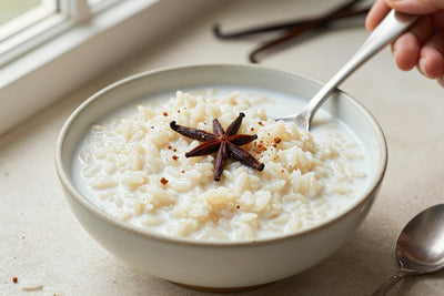 Creamy coconut rice pudding in a small ceramic bowl with a spoon, garnished as in the recipe