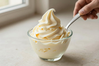 A generous swirl of fior di latte gelato in a small glass cup with a flat gelato spade