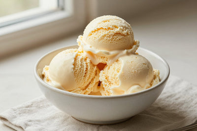 Two generous scoops of french vanilla ice cream in a shallow ceramic bowl, softly melting at the edges