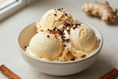 Two generous scoops of gingerbread ice cream in a shallow ceramic bowl, softly melting at the edges
