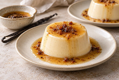 Gluten-Free Brown Butter Vanilla Panna Cotta, unmolded on a plate with vanilla beans