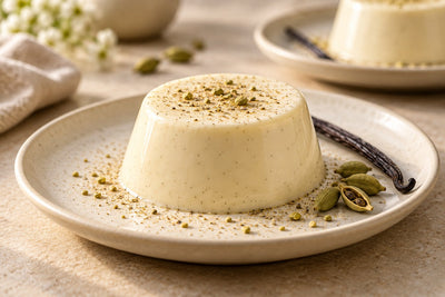 Gluten-Free Cardamom Vanilla Panna Cotta, unmolded on a plate with vanilla beans
