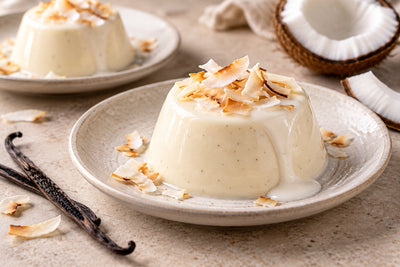 Gluten-Free Coconut Vanilla Panna Cotta, unmolded on a plate with vanilla beans