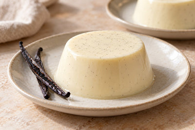 Gluten-Free Vanilla Panna Cotta, unmolded on a plate with vanilla beans