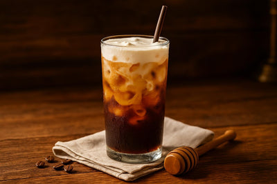 Honey Cold Brew in a glass on an oak table