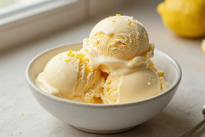 Two generous scoops of lemon cream ice cream in a shallow ceramic bowl, softly melting at the edges