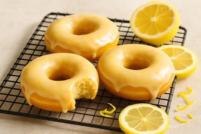 Doughnuts finished with lemon glaze on a cooling rack