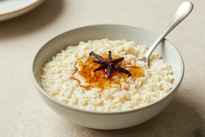 Creamy maple rice pudding in a small ceramic bowl with a spoon, garnished as in the recipe