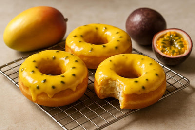 Doughnuts finished with passion fruit glaze on a cooling rack