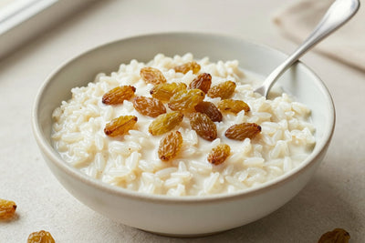 Creamy raisin rice pudding in a small ceramic bowl with a spoon, garnished as in the recipe