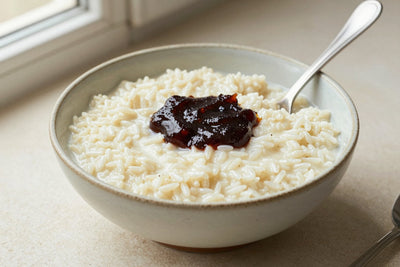 Creamy stovetop rice pudding in a small ceramic bowl with a spoon, garnished as in the recipe