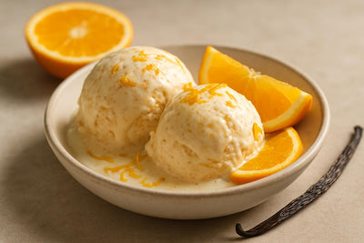 Scoops of vanilla orange cinnamon custard ice cream in a ceramic bowl