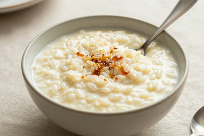 Creamy vanilla rice pudding in a small ceramic bowl with a spoon, garnished as in the recipe