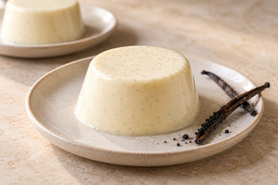 Vegan Vanilla Panna Cotta, unmolded on a plate with vanilla beans