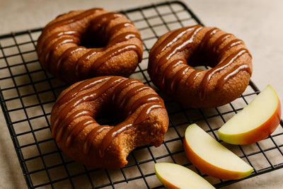 Doughnuts finished with apple butter drizzle on a cooling rack