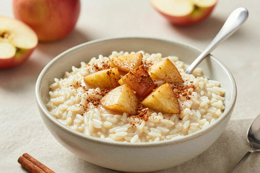 Creamy apple cinnamon rice pudding in a small ceramic bowl with a spoon, garnished as in the recipe