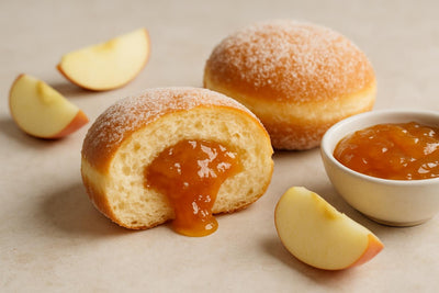 Filled doughnut cut open to show apple jam filling