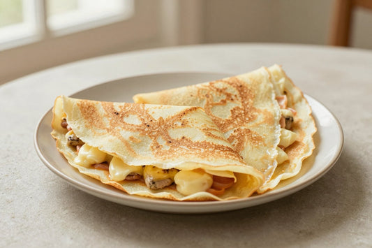 Folded basic french crêpes on a plate, the filling and toppings from the recipe clearly visible