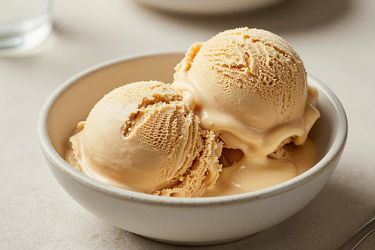 Two generous scoops of brown butter ice cream in a shallow ceramic bowl, softly melting at the edges