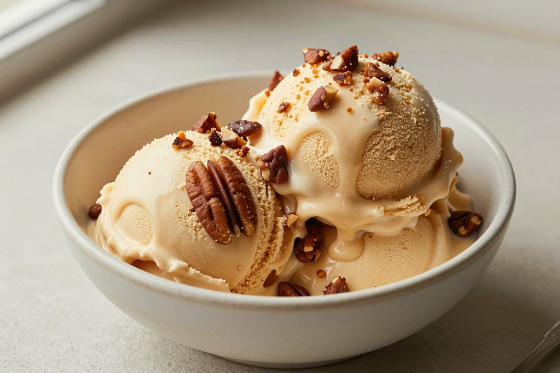 Two generous scoops of brown butter pecan ice cream in a shallow ceramic bowl, softly melting at the edges