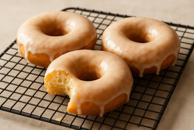 Doughnuts finished with buttermilk glaze on a cooling rack