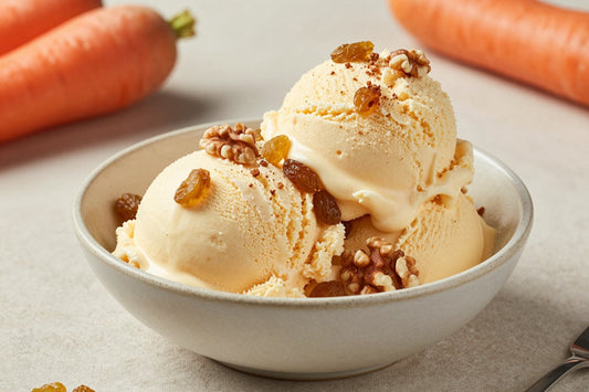 Two generous scoops of carrot cake ice cream in a shallow ceramic bowl, softly melting at the edges