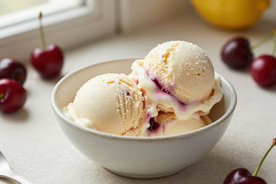 Two generous scoops of cherry vanilla ice cream in a shallow ceramic bowl, softly melting at the edges