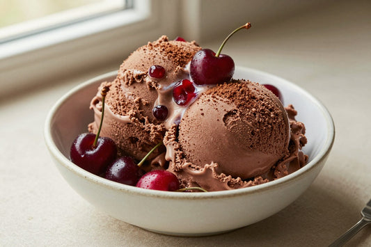 Two generous scoops of chocolate cherry ice cream in a shallow ceramic bowl, softly melting at the edges