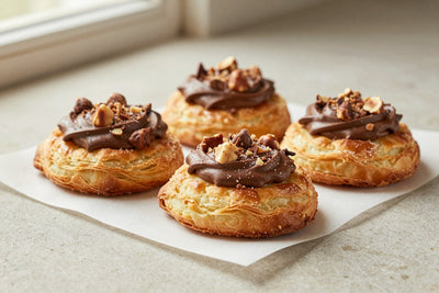 Chocolate hazelnut puff pastry on parchment, showing crisp, flaky, deep golden layers