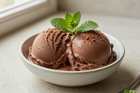 Two generous scoops of chocolate mint ice cream in a shallow ceramic bowl, softly melting at the edges
