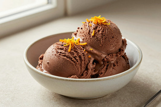 Two generous scoops of chocolate orange ice cream in a shallow ceramic bowl, softly melting at the edges