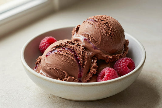 Two generous scoops of chocolate raspberry ice cream in a shallow ceramic bowl, softly melting at the edges