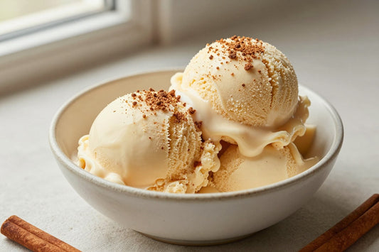 Two generous scoops of cinnamon ice cream in a shallow ceramic bowl, softly melting at the edges