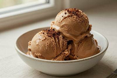Two generous scoops of coffee ice cream in a shallow ceramic bowl, softly melting at the edges