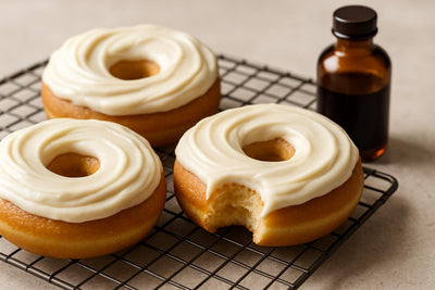 Doughnuts finished with cream cheese frosting on a cooling rack