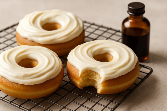 Doughnuts finished with cream cheese frosting on a cooling rack