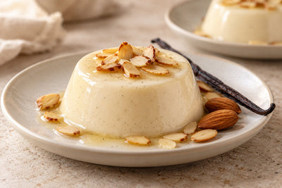 Dairy-Free Almond Vanilla Panna Cotta, unmolded on a plate with vanilla beans