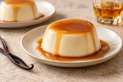 Dairy-Free Bourbon Vanilla Panna Cotta, unmolded on a plate with vanilla beans