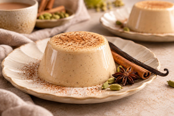 Dairy-Free Chai Vanilla Panna Cotta, unmolded on a plate with vanilla beans