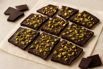 Shards of dark chocolate pistachio bark on parchment
