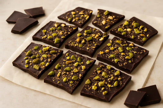 Shards of dark chocolate pistachio bark on parchment