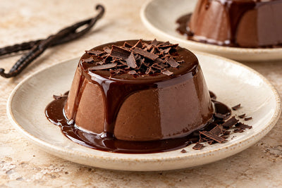 Gluten-Free Dark Chocolate Vanilla Panna Cotta, unmolded on a plate with vanilla beans