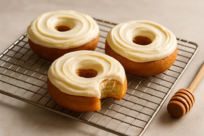 Doughnuts finished with honey mascarpone frosting on a cooling rack