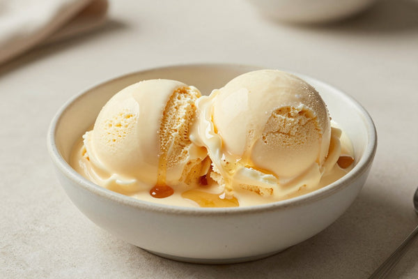 Two generous scoops of maple ice cream in a shallow ceramic bowl, softly melting at the edges